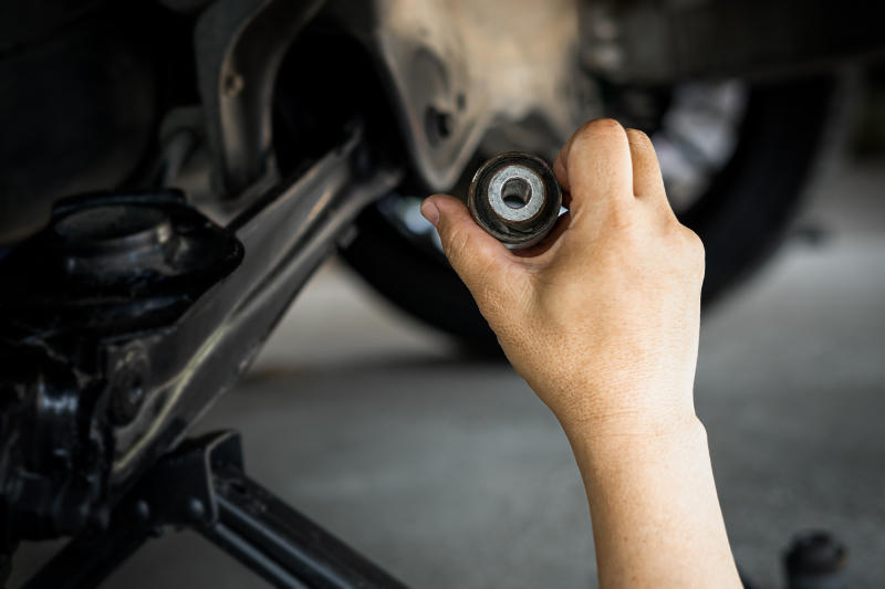 A mechanic carefully tightening bolts while repairing a faulty car suspension.